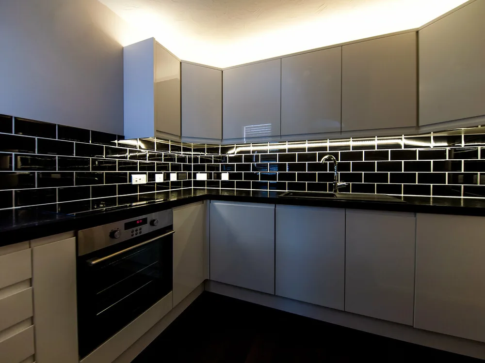 Cocina reformada con mobiliario blanco y alicatado negro